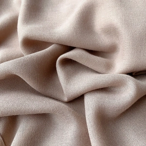 Gros plan du tissu en lin beige montrant la texture douce et le détail de tissage fin