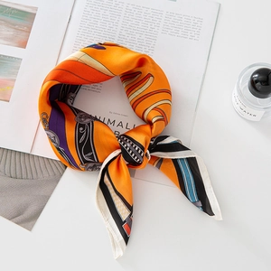 French vintage chain print silk scarf in bright orange and purple on a magazine
