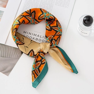 Orange maple leaf print silk scarf with green borders on a minimalist white background