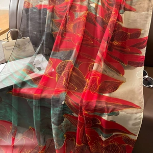 Eleganter Seidenschal mit rotem Lotustextur-Druck vor dunklem Lederhintergrund