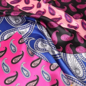 Detailansicht der glatten Satinstruktur und des farbenfrohen Paisley-Musters des Schals