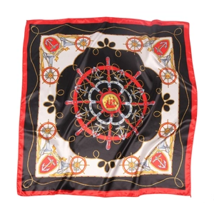 Detail of nautical silk scarf featuring golden anchor and helm patterns on black fabric