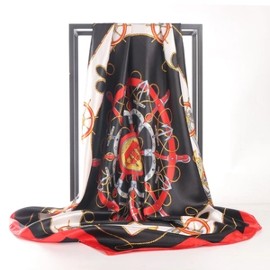 Elegant silk scarf with gold compass and anchor print hanging on a black metal stand