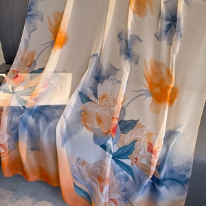 Elegant floral print shawl in orange and light blue silk-like fabric with soft drape
