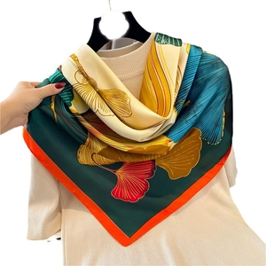 Seidenschal mit Ginkgoblatt-Muster und farbenfrohem Design auf hellem Pullover