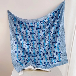 Elegant blue silk square scarf with geometric circle patterns and paisley border details