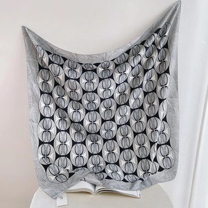 Detail of geometric circle print silk scarf with paisley border on display books