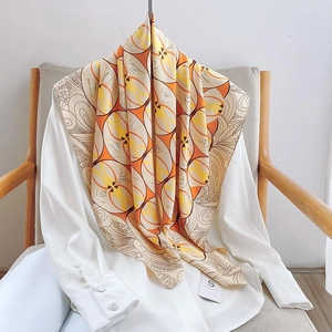 Detail of silk scarf with orange geometric floral pattern draped over a white shirt