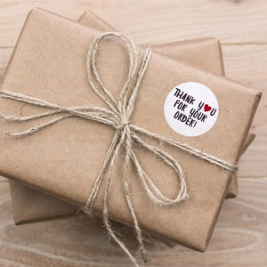 Autocollants ronds Thank You sur une boîte cadeau en kraft avec ficelle naturelle