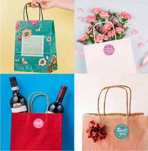 Application of floral Thank You stickers on gift bags and boxes for wedding favors