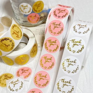 Roll of kraft thank you labels with gold foil letters for gift packaging and envelopes