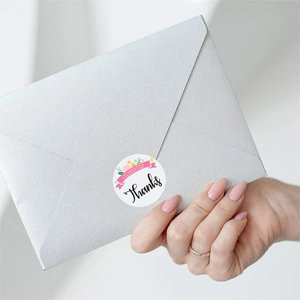 Close-up of floral Thank You sticker sealing a silver envelope for wedding gift