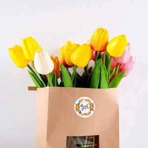 Floral thank you sticker on brown paper bag with tulips for wedding gift packaging