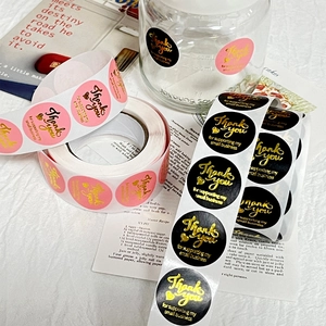 Pink and black round thank you stickers with gold foil lettering for gift packaging