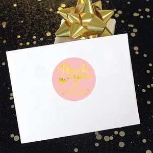 Pink and gold foil Thank You stickers on a white envelope for gift packaging