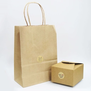 Geschenktüten und Boxen aus Kraftpapier mit runden Thank You Aufklebern und Hanfseil