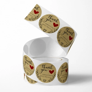 Brown kraft paper thank you stickers roll with black text and red hearts for packaging