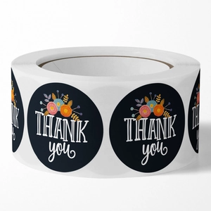 Roll of black floral Thank You stickers with elegant white lettering for gift packaging