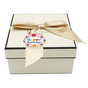 Top view of a gift box with a champagne bow and Happy Birthday decorative round sticker