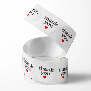 Roll of round white 'thank you' stickers with red heart for gift packaging seals