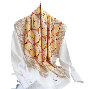 Fashionable geometric print silk scarf with warm orange and yellow pattern on white shirt