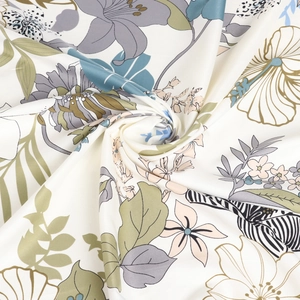 Detail of silk-like floral scarf fabric showing smooth texture and botanical patterns
