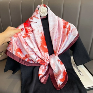 Rotes Seidentuch mit Blumenmuster und weinrotem Rand auf schwarzem Pullover