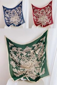 Détail de foulards carrés en satin de luxe avec imprimés rétro de fleurs et oiseaux