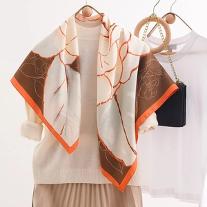 Eleganter 90x90cm Seidenschal mit Kamelien-Print und orangefarbenem Rand auf dem Pullover