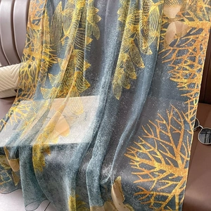Élégant châle en soie bleu et jaune drapé sur un canapé en cuir avec accessoires de mode