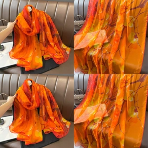 Elegant orange silk scarf with persimmon prints, perfect for beach and vacation travel