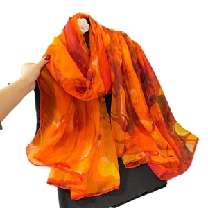 Elegant oversized floral print scarf in orange and red for beach vacation and travel