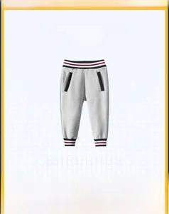 Détail du jogging gris pour enfant avec bords-côtes et taille à rayures rouges, blanches, bleues