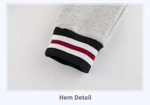 Détail du jogging gris avec poignets côtelés et rayures tricolores élégantes