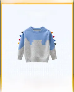 Detail of boys' dinosaur knit sweater with blue and grey patchwork and 3D spikes