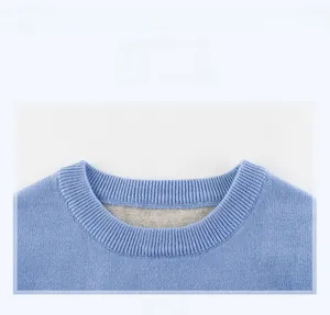Close-up of the ribbed crew neck and fine knit texture of this light blue boys' sweater