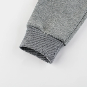 Détails rapprochés de pantalons de sport gris pour enfants avec poignets côtelés