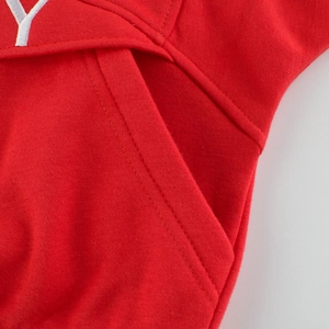 Close-up of red cotton hoodie with white letter Y embroidery and double-stitch pockets