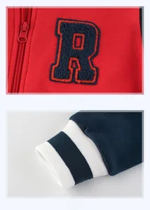 Detail of red collegiate jacket featuring towel-embroidered letter R and ribbed cuffs