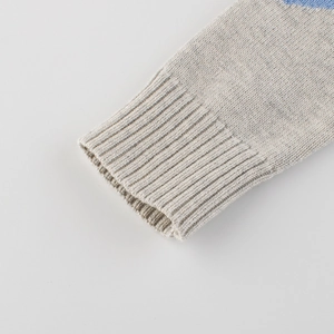 Close-up of boys knitted sweater featuring ribbed cuffs and blue stripe detail