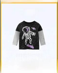 Detail of boys long sleeve t-shirt featuring astronaut skateboarding print and color block