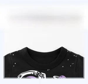 Macro view of a black cotton t-shirt collar featuring detailed astronaut and space prints