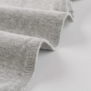 Gros plan du tissu en maille gris clair avec double couture sur un t-shirt enfant