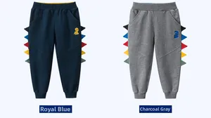 Dettaglio di joggers per bambini blu navy e grigio antracite con accenti dinosauro 3D