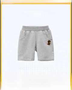 Detail of grey cotton knit shorts for boys featuring a cute dinosaur embroidery patch