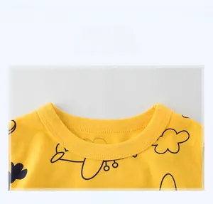 Gros plan d'un t-shirt jaune pour enfant avec col rond et motif d'avion de dessin animé