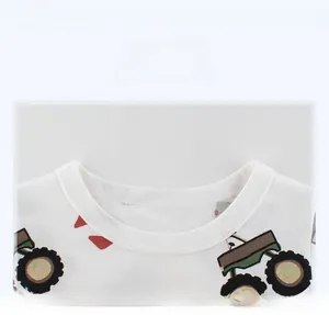 Close-up of ribbed crew neck and cartoon tractor print on white cotton kids t-shirt