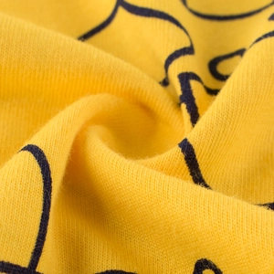 Gros plan sur le tissu en coton jaune pour t-shirt garçon avec texture respirante