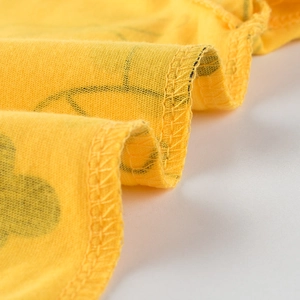 Détail de t-shirt enfant jaune en coton avec couture ondulée et imprimé dessin animé