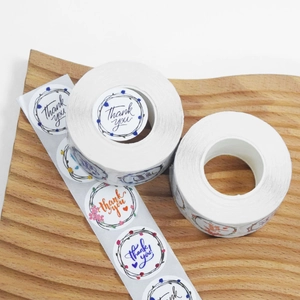 Roll of floral thank you stickers for gift sealing on decorative wooden tray